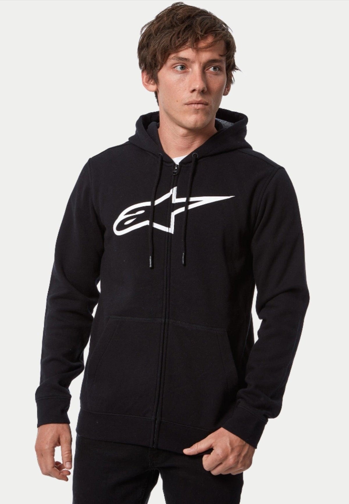 Sudadera con capucha Alpinestars Ageless Zip V3, sudadera con cremallera frontal, en negro y blanco, con un gran logotipo blanco de Alpinestars en el pecho, capucha con cordón y cierre de cremallera completa, estilo streetwear casual