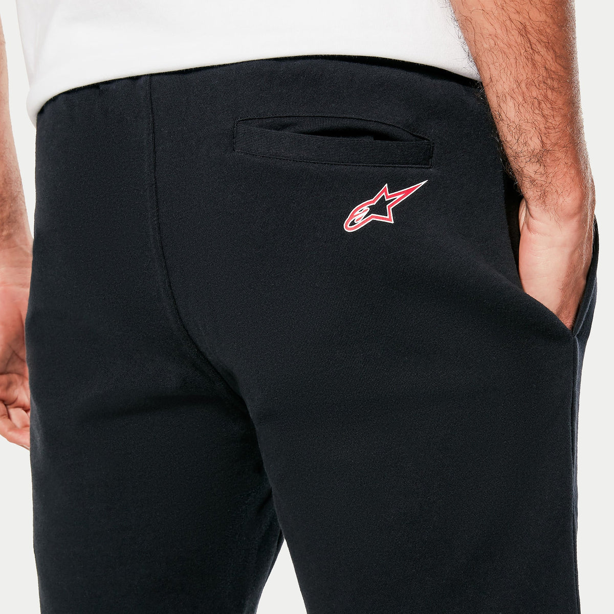 Alpinestars Dunker Short, detalle de short de entrenamiento negro para hombre, primer plano del bolsillo trasero de ribete y el logotipo Ageless en la cadera, confeccionado en forro polar cómodo