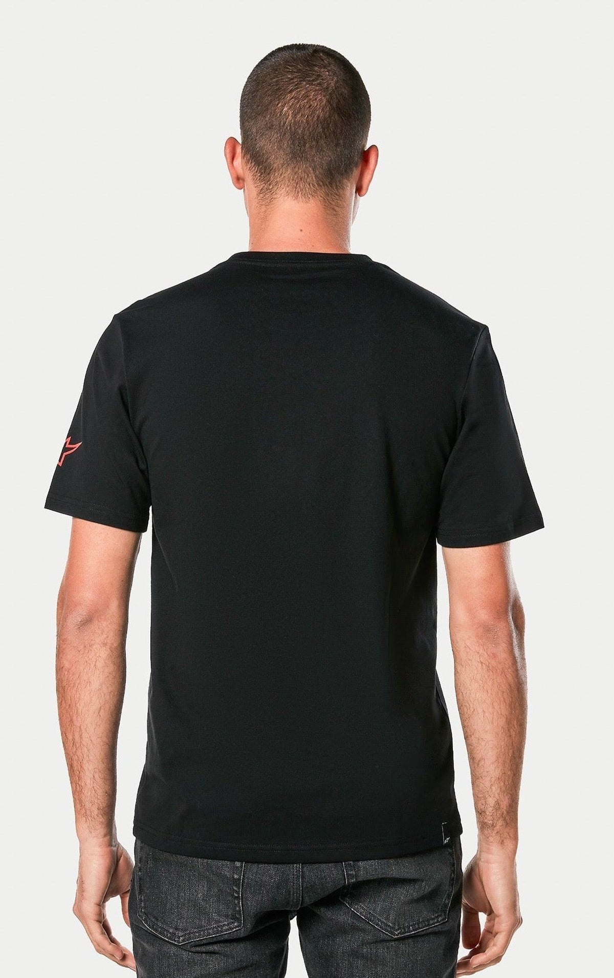 Alpinestars Linear Wordmark 2.0 CSF Tee, Black, back view of a person wearing the short-sleeve T-shirt, featuring a red Ageless logo on the sleeve, casual motorsport streetwear.