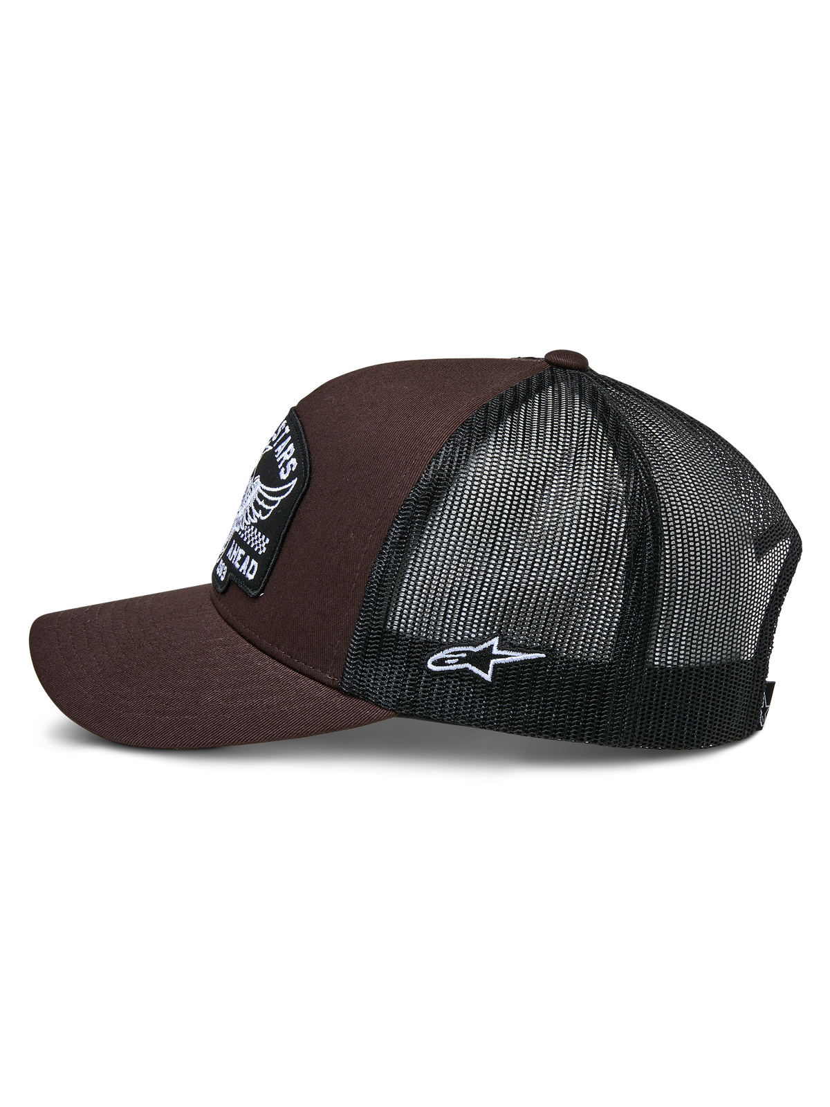 Gorra Trucker Heritage Patch de Alpinestars, marrón y negro, vista lateral que muestra la parte frontal de sarga marrón y la parte trasera de malla negra, parche lateral blanco con el logotipo Ageless, corona estructurada y visera curva