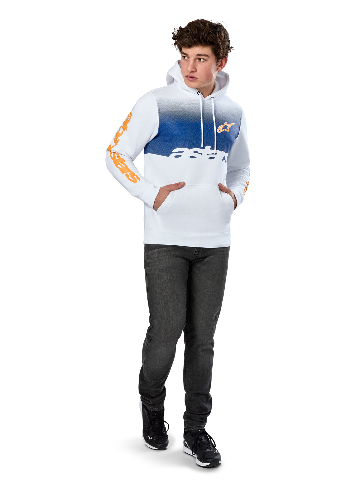 Sudadera con capucha Alpinestars Specter, forro polar blanco con estampado degradado azul, logotipo frontal HD naranja y marcas en las mangas, con bolsillo canguro y capucha con cordón, combinada con vaqueros oscuros para un look casual inspirado en el motociclismo.