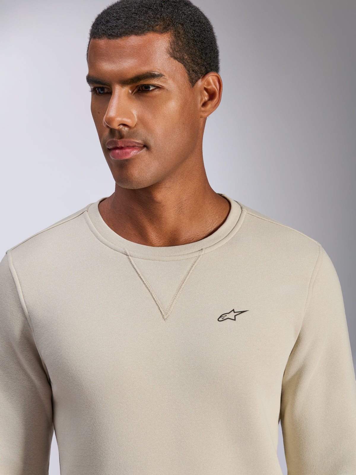 Sudadera Alpinestars Positive Crew, blanco roto, sudadera de cuello redondo con pequeño logotipo de estrella negro en el pecho, detalle de costura en V en el cuello, ropa casual de estilo de vida inspirada en el automovilismo