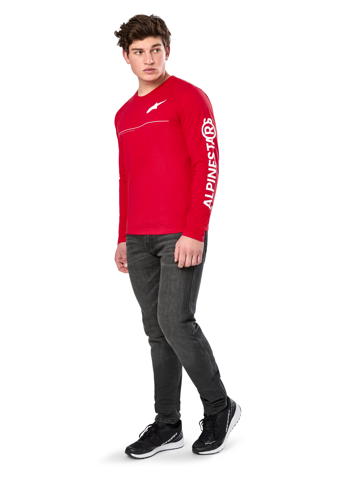 Alpinestars Committed CSF Tee, camiseta de manga larga, roja, con el logotipo Astars blanco en el pecho y la marca Alpinestars en la manga, lucida por un modelo con vaqueros oscuros y zapatillas negras, estilo casual motorsport