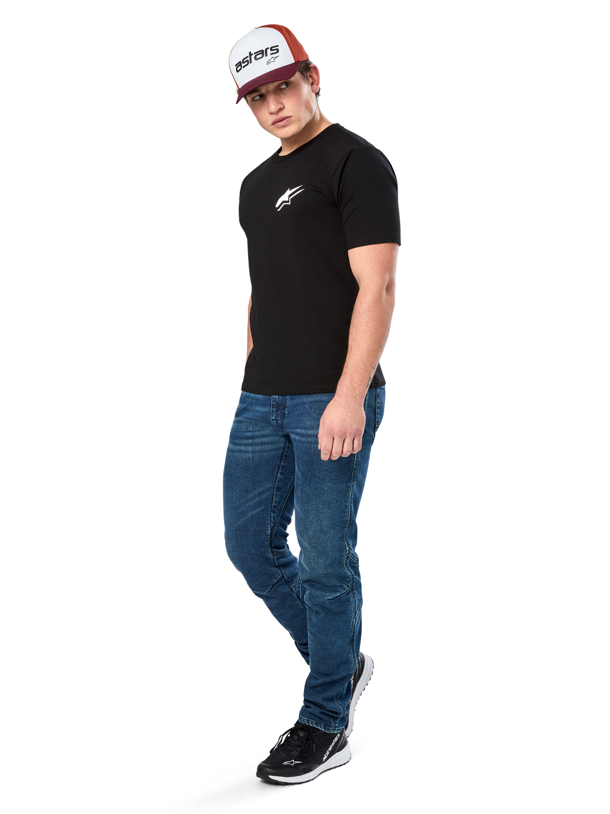 Alpinestars Formulate Csf Tee, camiseta de manga corta, negra con logo Astars blanco en el pecho, usada por un modelo con vaqueros azules, gorra granate y blanca, y zapatillas negras, ropa urbana casual inspirada en el automovilismo