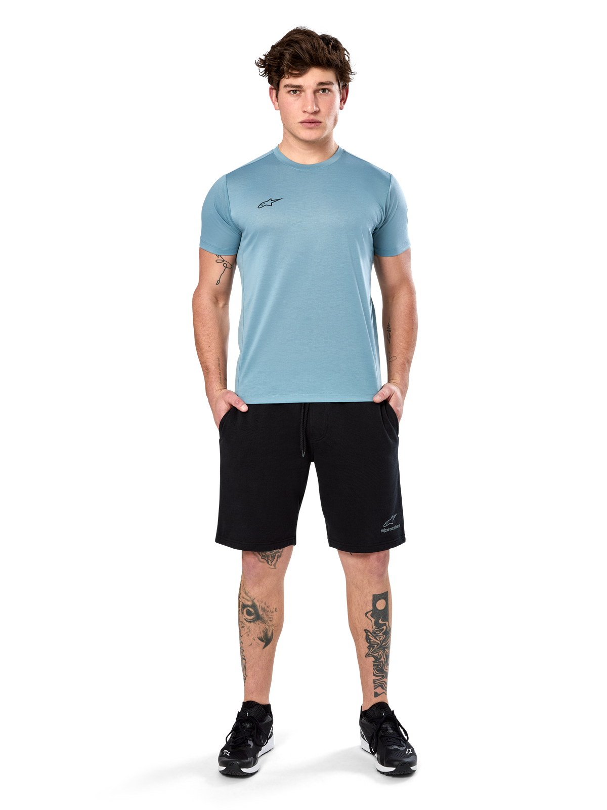Camiseta Alpinestars Point Performance, camiseta de manga corta, azul hielo, con un pequeño logotipo frontal negro, cuello redondo, usada por un modelo con pantalones cortos y zapatillas negras, ropa deportiva casual con absorción de humedad