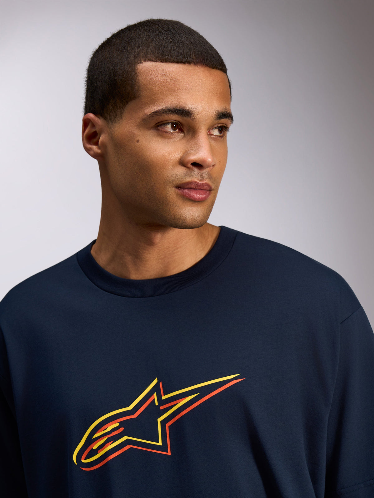 Alpinestars Alter Oversized CSF Tee, Short Sleeve T-Shirt, Navy, Astars logo with yellow and orange color off-set print, casual streetwear style worn by a model