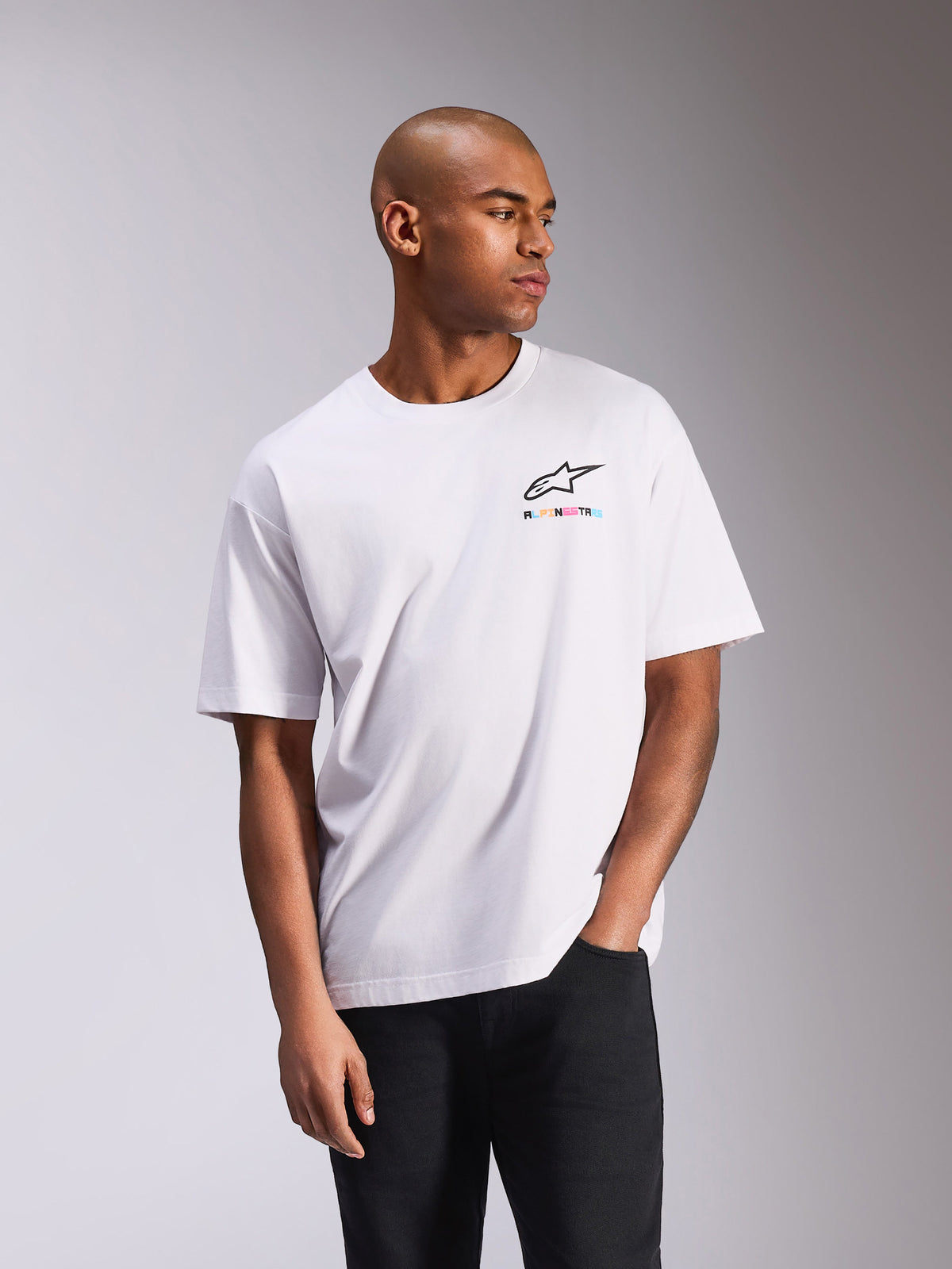 Alpinestars Wild Oversized CSF Tee, camiseta de manga corta, blanca, con un pequeño logo Astars multicolor en el pecho, silueta de corte grande, estilo streetwear casual inspirado en el automovilismo