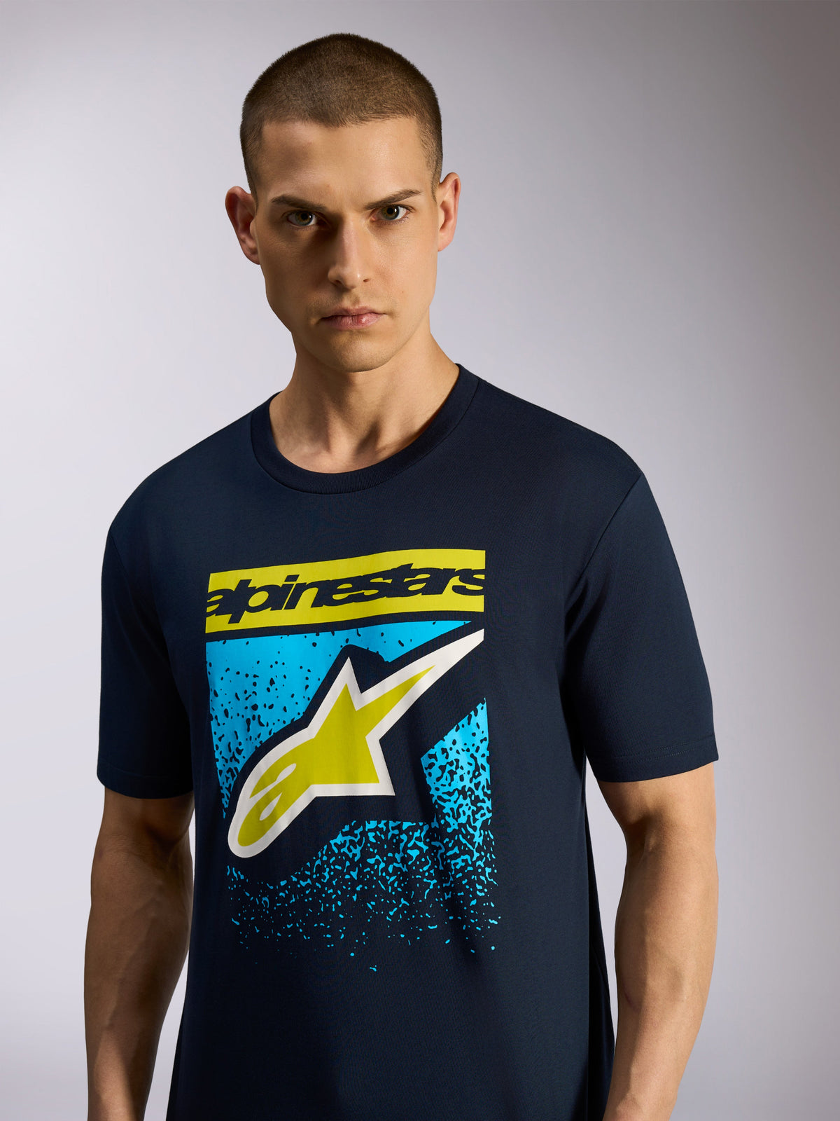 Alpinestars Noka CSF Tee, camiseta de manga corta, azul marino, presenta el logotipo frontal de Astars con letras en amarillo y un gráfico moteado azul, ropa deportiva casual de motor