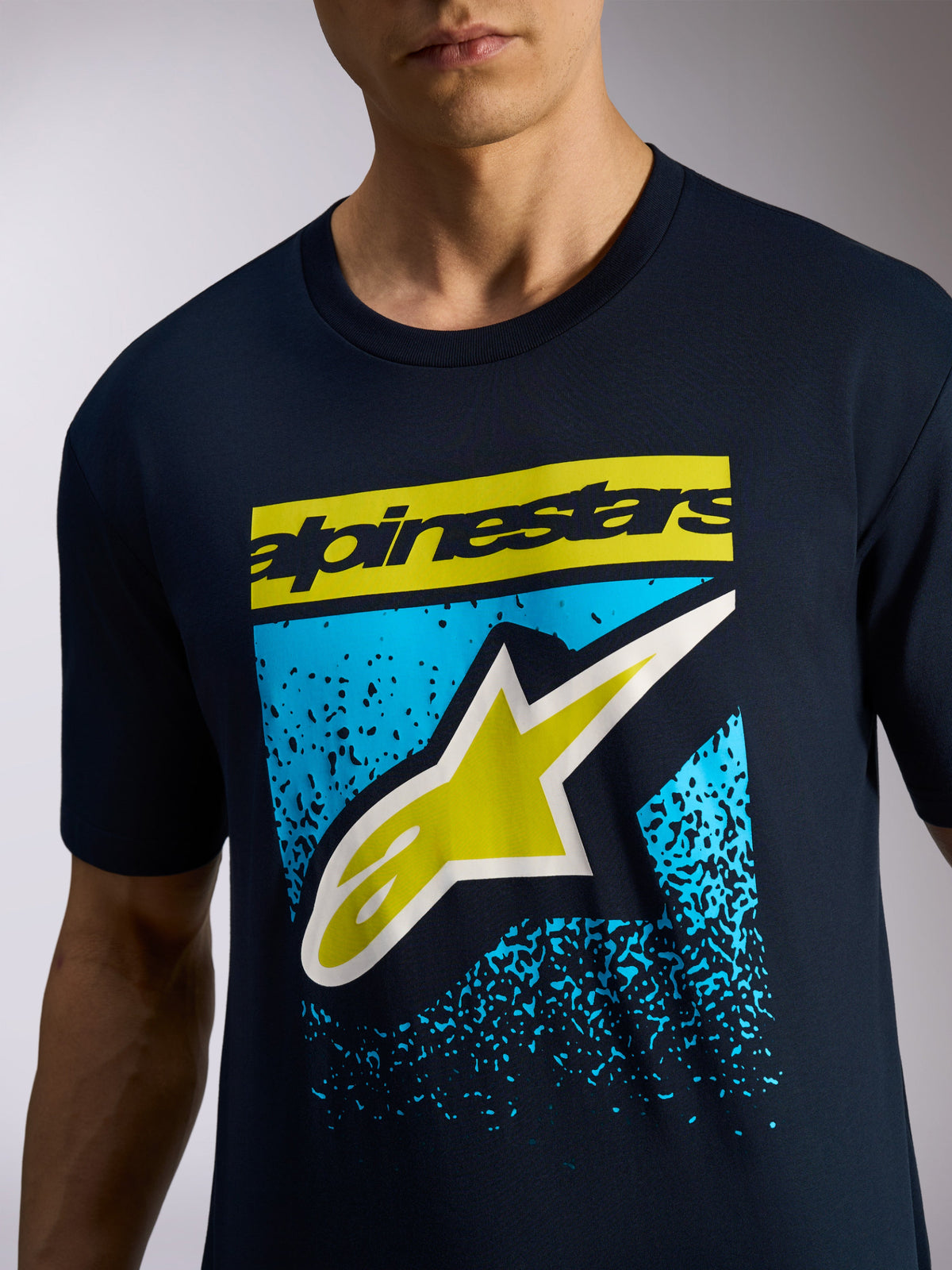 Camiseta Alpinestars Noka CSF, camiseta de manga corta, azul marino, nombre de marca Alpinestars en amarillo y logo A-star con gráfico de degradado MX en azul, ropa deportiva casual de estilo motorsport