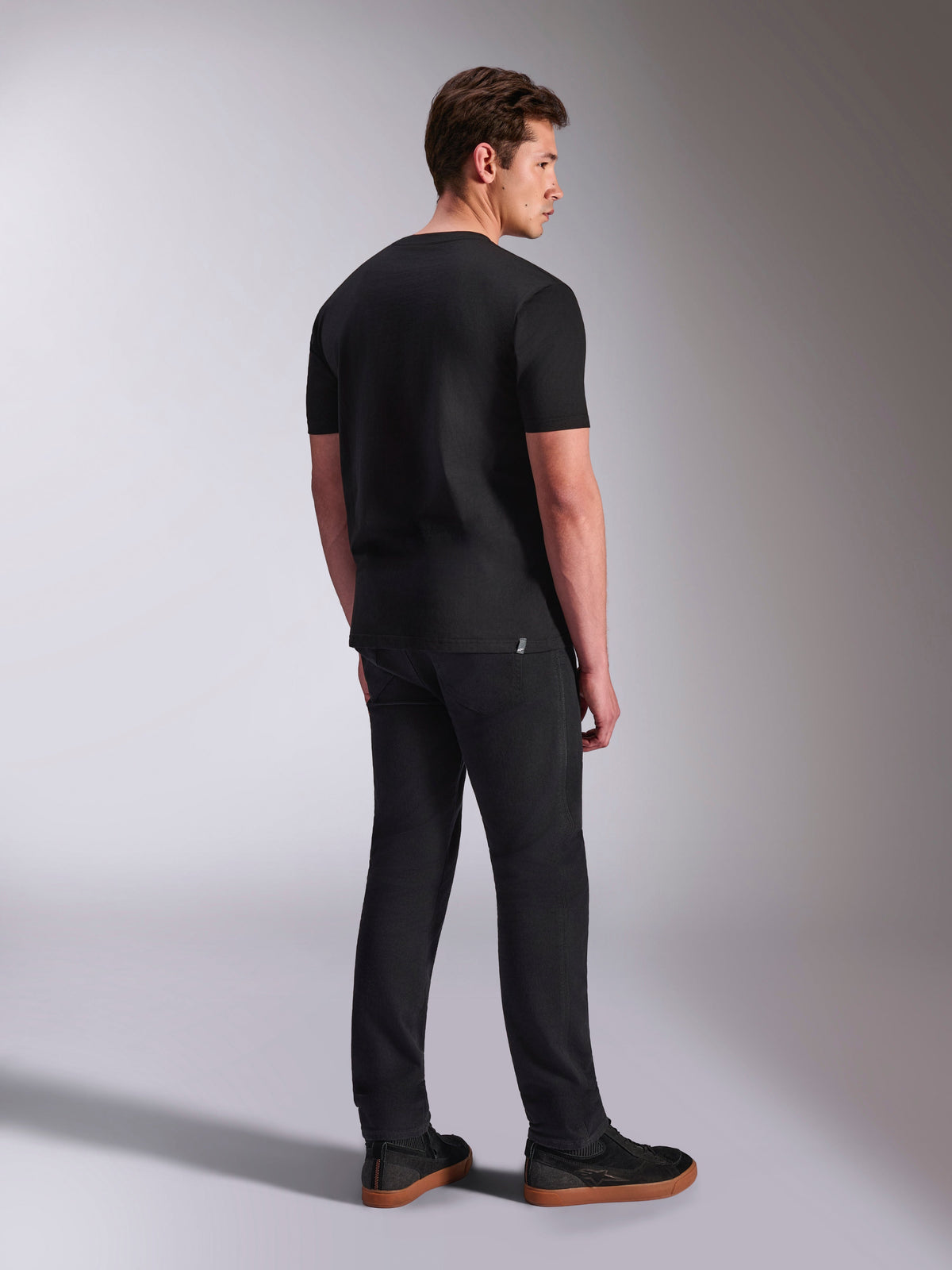 Alpinestars Abus CSF Tee, Short Sleeve T-Shirt, Black, back view on male model, casual motorsport streetwear, paired with dark pants and sneakers