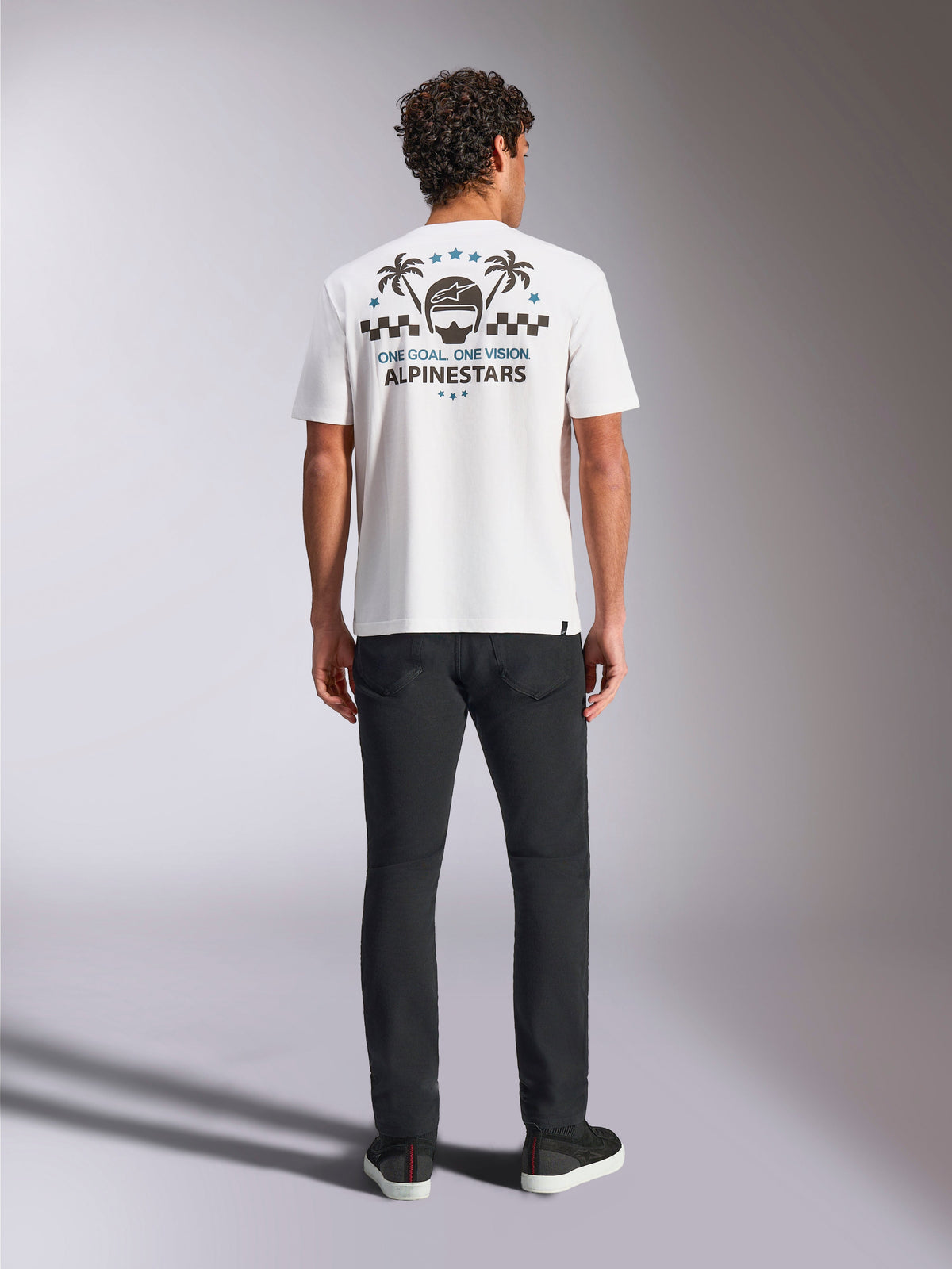 Alpinestars Order CSF Tee, camiseta de manga corta en color blanco, vista posterior con gráfico de casco y palmeras, patrón de cuadros y marca Alpinestars, ropa deportiva casual de motorsport