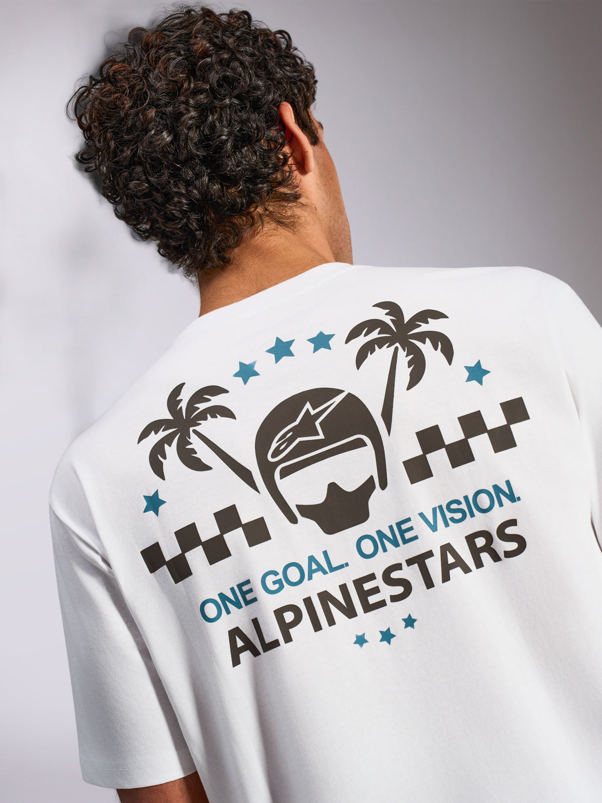 Alpinestars Order CSF Tee, camiseta de manga corta, blanca, vista trasera con gráfico de casco, palmeras y texto 'ONE GOAL. ONE VISION.', estilo casual de motociclismo streetwear