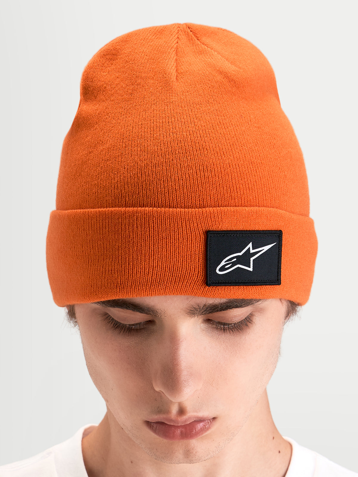 Gorro Alpinestars Augment Cuff, gorro de punto de sportswear, naranja, con silueta de ajuste profundo y parche tejido con el logo Astars negro en el dobladillo, vista en modelo