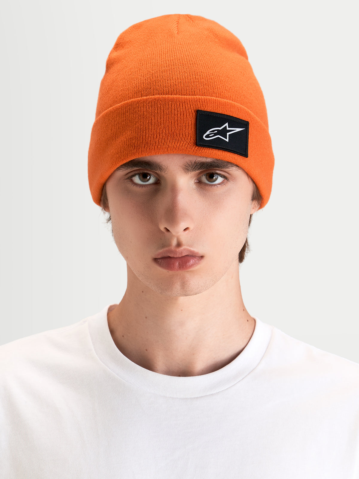 Gorro Alpinestars Augment Cuff, gorro sportswear de punto jersey con silueta de ajuste profundo, naranja, con parche tejido Astars, vista frontal en modelo