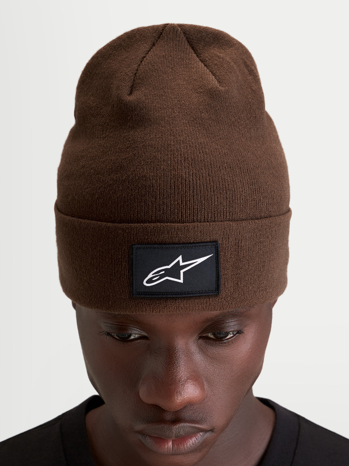 Gorro Alpinestars Augment Cuff, gorro de invierno de punto para sportswear, marrón, con parche negro tejido con logo Astars blanco, vista frontal en modelo