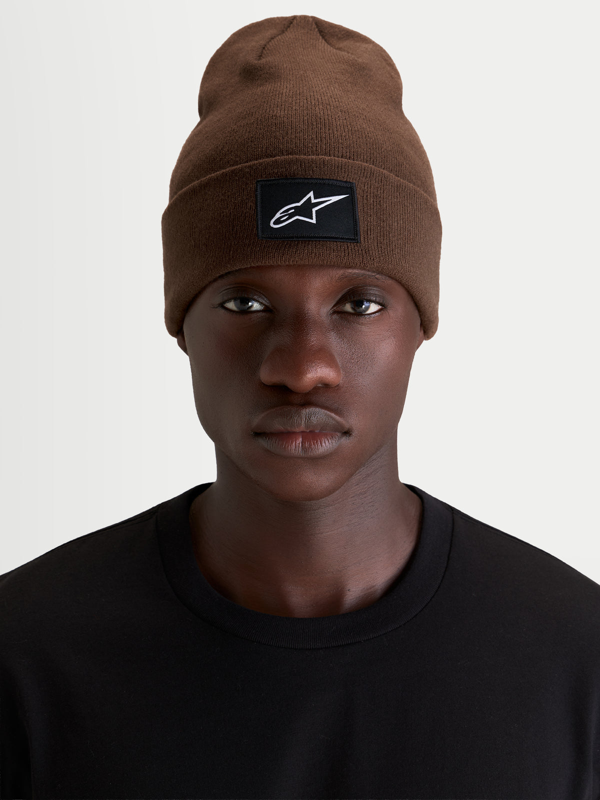 Gorro Augment Cuff Alpinestars, gorro casual sportswear de punto, marrón con parche tejido del logo en el dobladillo, vista frontal en modelo con camiseta negra
