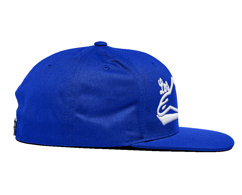 Gorra Alpinestars Los Angeles, gorra snapback azul, vista de perfil lateral, con visera plana y corona estructurada, sarga de algodón azul brillante con bordado 3D blanco, ropa deportiva casual.