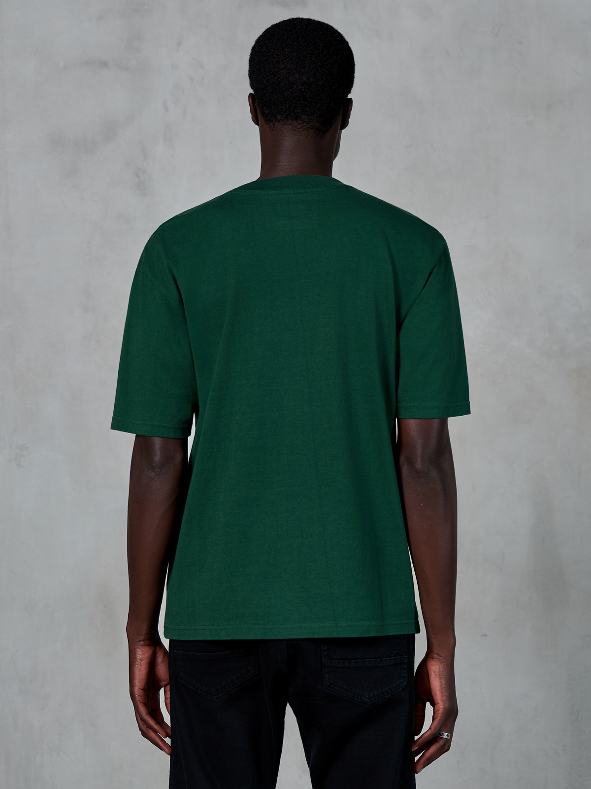 Alpinestars Essentials Ageless SS Tee, camiseta de manga corta, verde pino, vista posterior en modelo, ajuste relajado, algodón orgánico, ropa urbana casual inspirada en el motociclismo