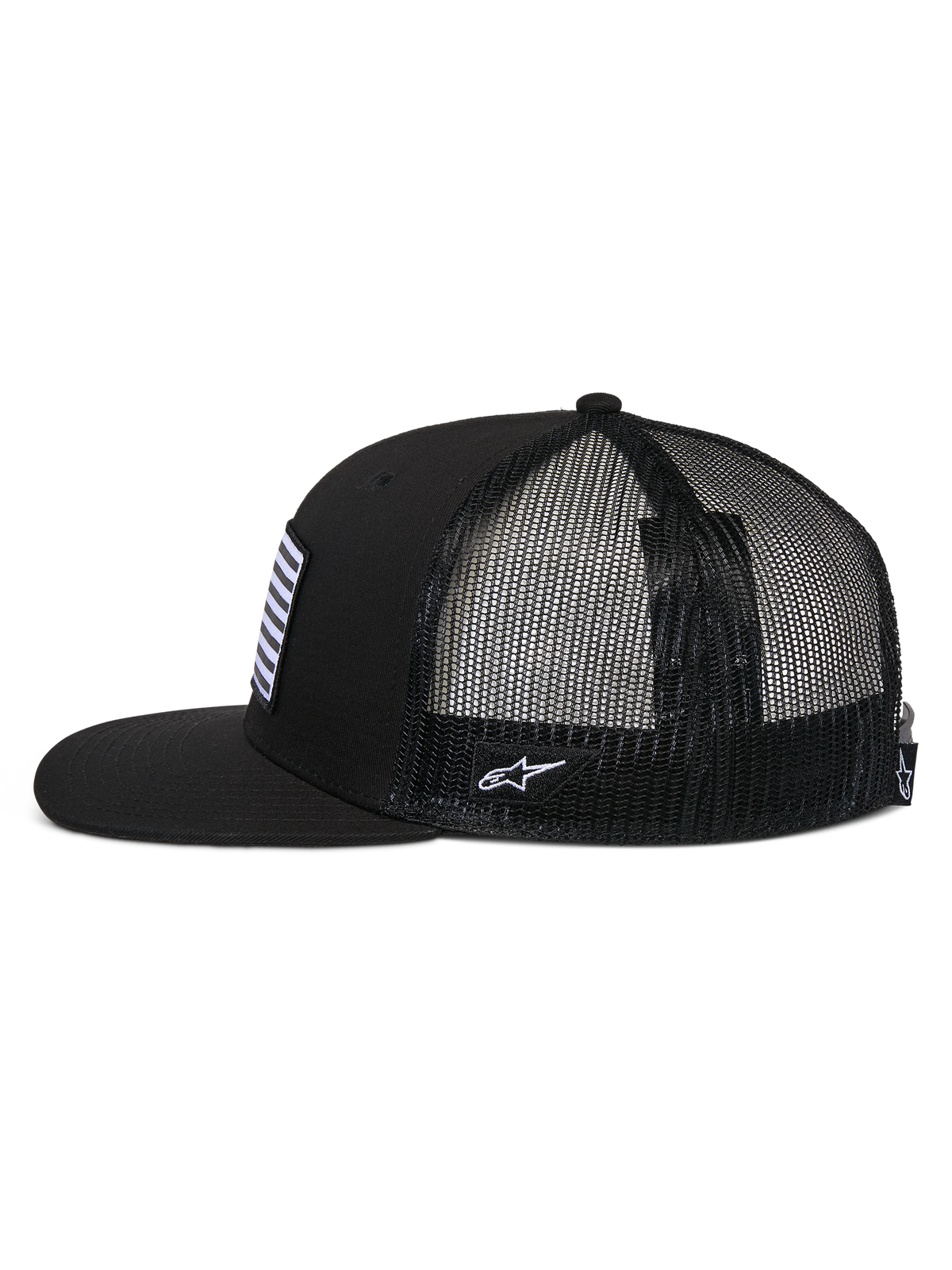 Gorra Trucker Plana Flag de Alpinestars, perfil lateral, negra, visera plana y corona estructurada, parte trasera de malla de poliéster transpirable, parche frontal de bandera y bordado de logotipo lateral blanco, accesorio de cabeza informal inspirado en el automovilismo