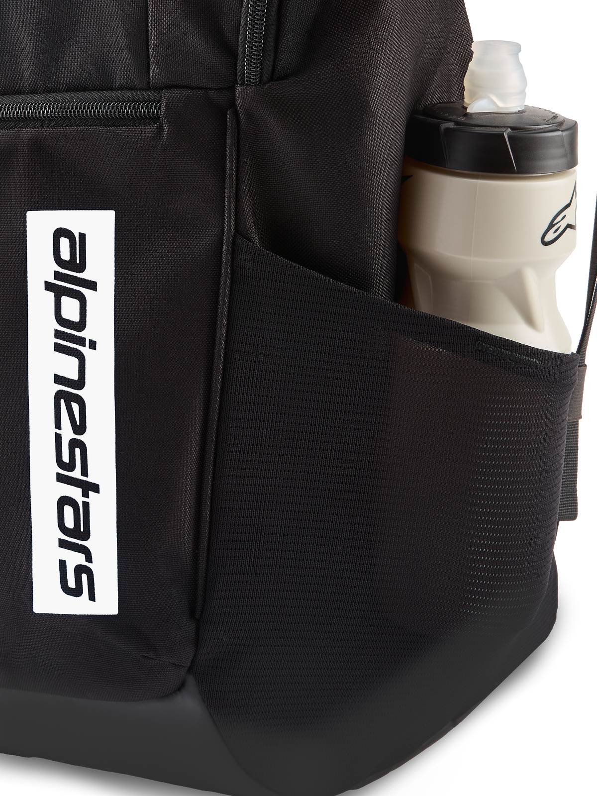 Mochila Alpinestars Defcon V3, mochila negra para uso diario, primer plano del bolsillo lateral de malla con botella de agua, logotipo blanco vertical en la parte delantera, material de poliéster 600D duradero