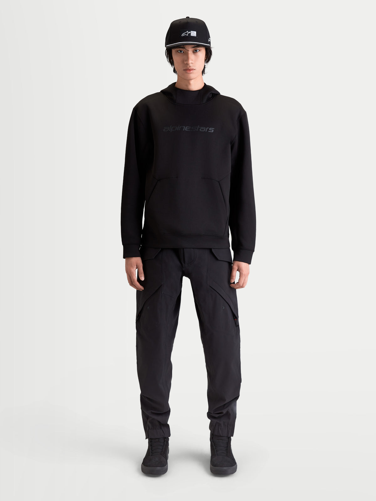 Alpinestars Sudadera con capucha Datrix, sudadera de estilo casual inspirado en el motorsport para hombre, color negro, con logotipo tonal en el pecho, forro polar de doble cara y bolsillo frontal con detalle de pliegue, mostrado en modelo
