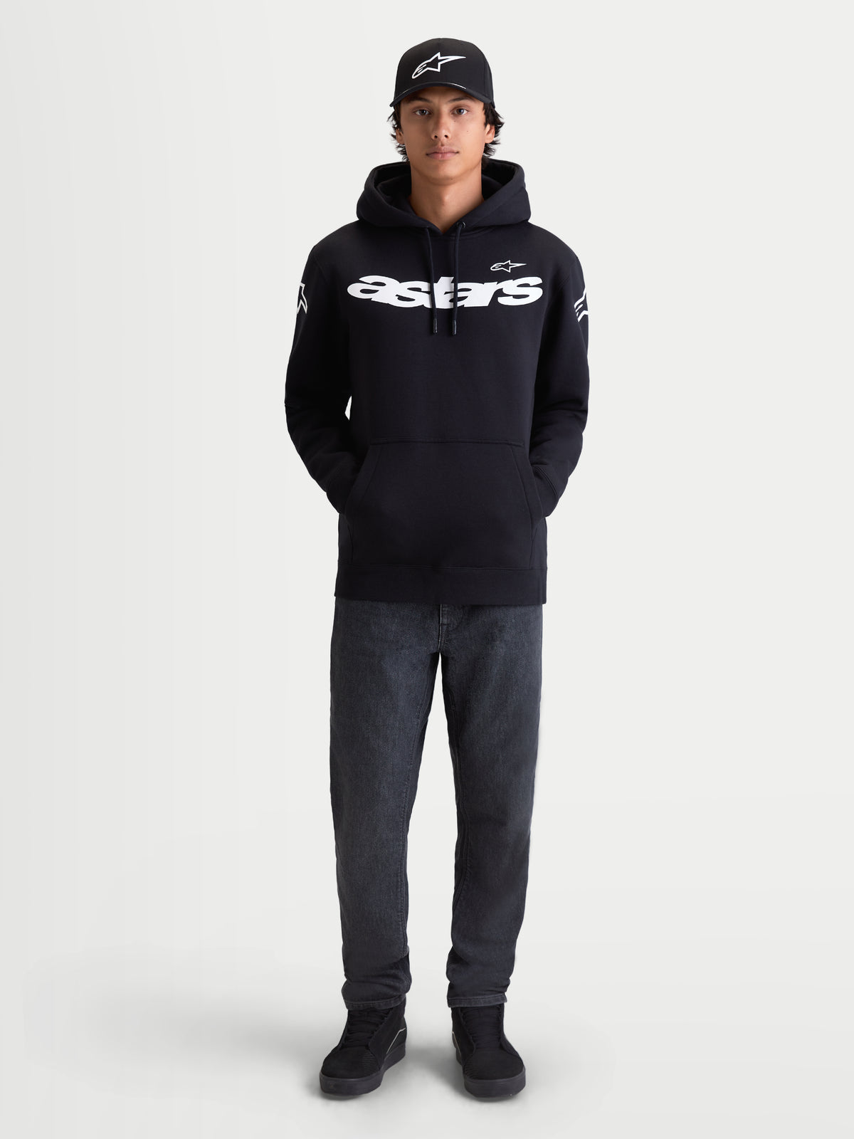 Alpinestars sudadera con capucha Velocifier, sudadera de hombre de forro polar, ropa deportiva para uso casual, negra con logotipos Astars blancos en el pecho y los hombros, confeccionada en mezcla de algodón premium, mostrada en modelo con gorra a juego