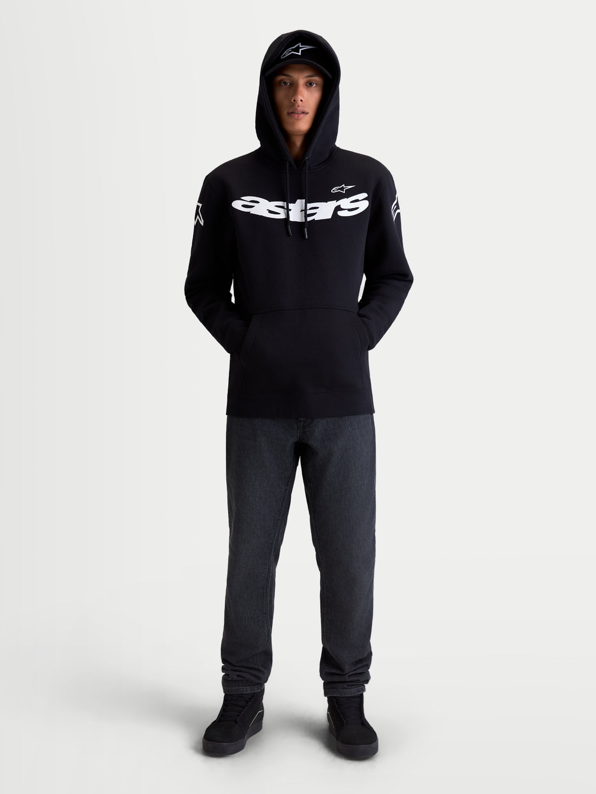Alpinestars Sudadera con capucha Velocifier, sudadera de estilo casual inspirado en el motorsport, negra y blanca, con logotipo Astars en el pecho y en los hombros, mezcla de algodón y poliéster reciclado, vista frontal en modelo.