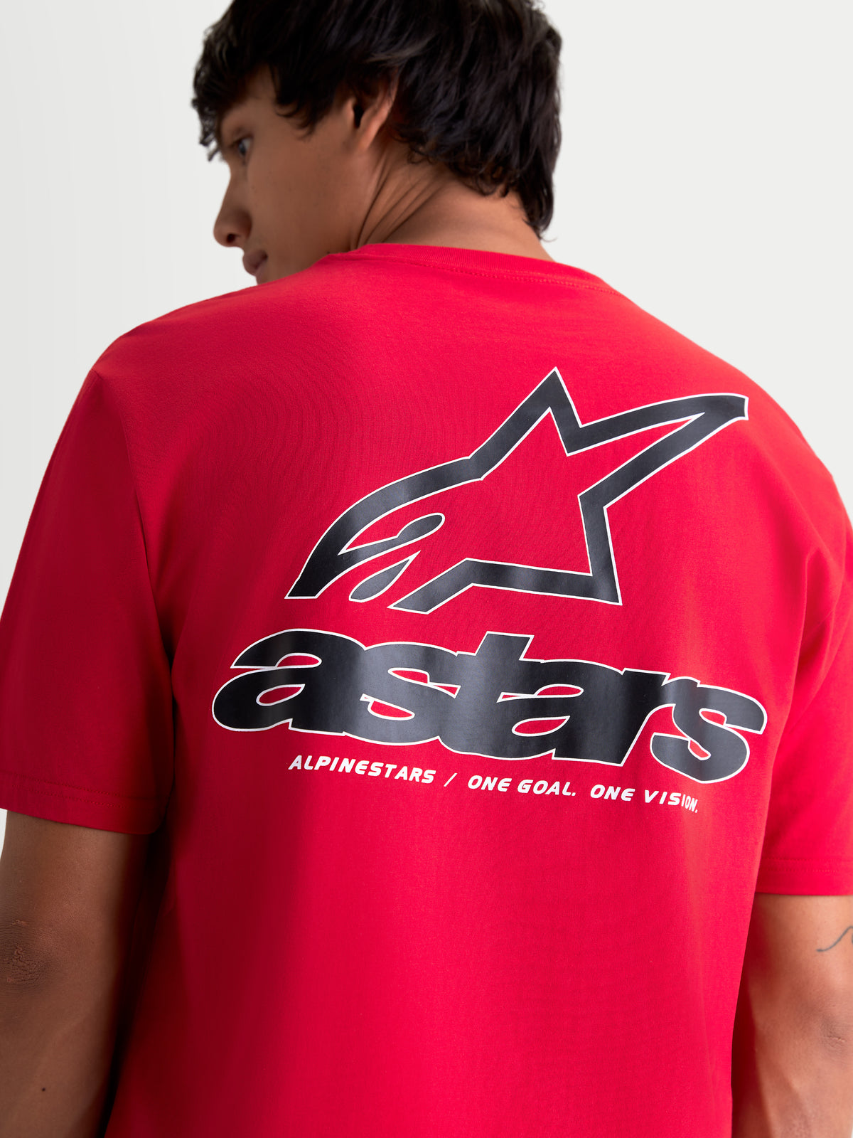 Alpinestars Lineout CSF, camiseta de mangas cortas roja con gráficos negros y blancos, vista trasera en modelo con logotipo Astars y lema One Goal. One Vision., ropa deportiva