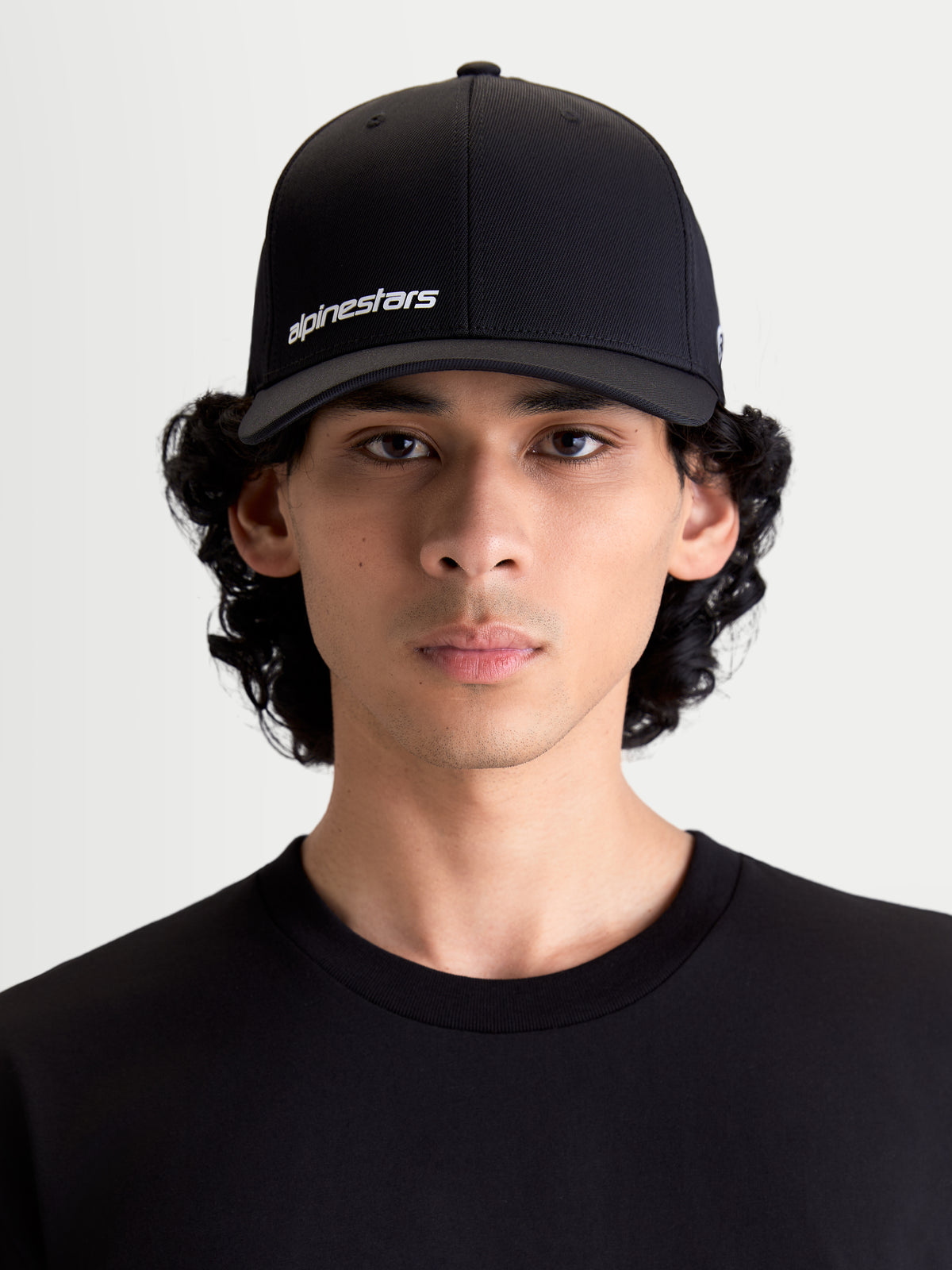 Alpinestars Gorra Points, gorra de béisbol de estilo sportswear para hombre y mujer, negra y blanca, tejido de nylon tactel ligero, ajuste flex-back, vista frontal en modelo