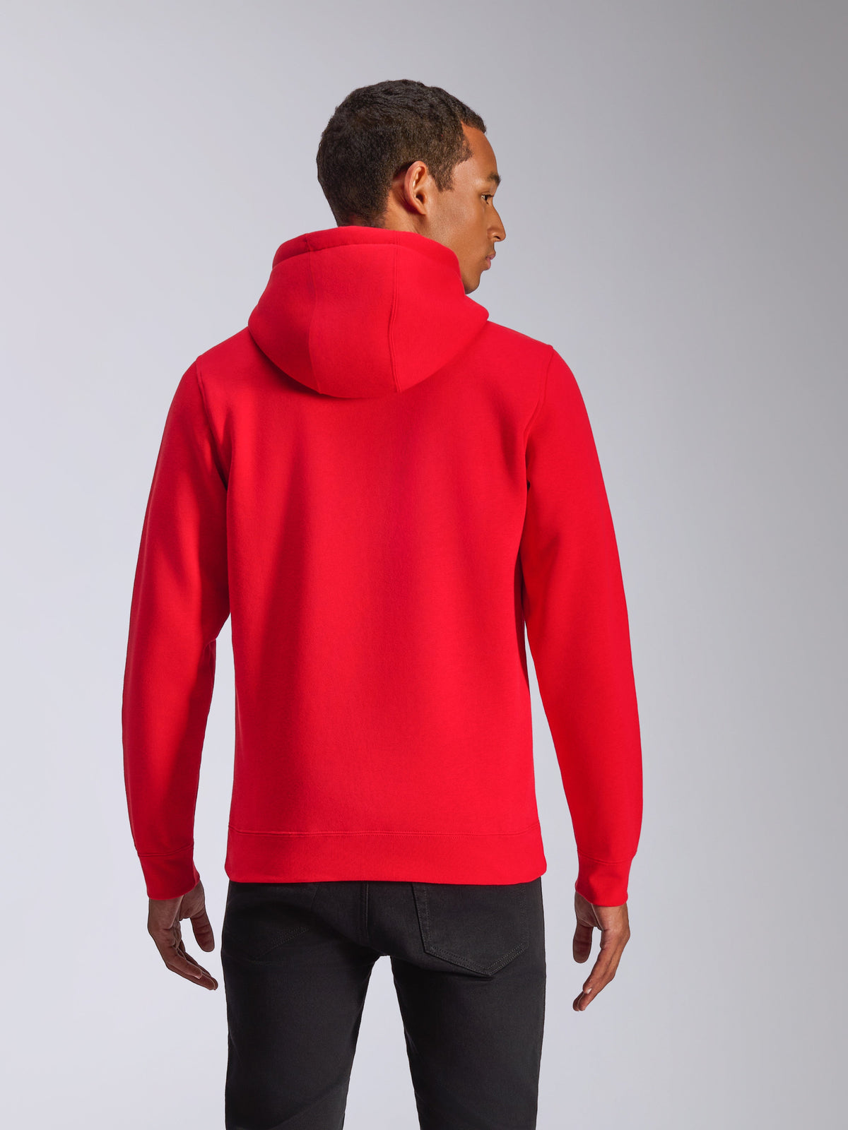 Sudadera Alpinestars Ageless V3, vista trasera, sudadera roja con capucha, ropa deportiva casual con capucha con forro de jersey y puños de canalé, usada por un modelo con pantalones negros