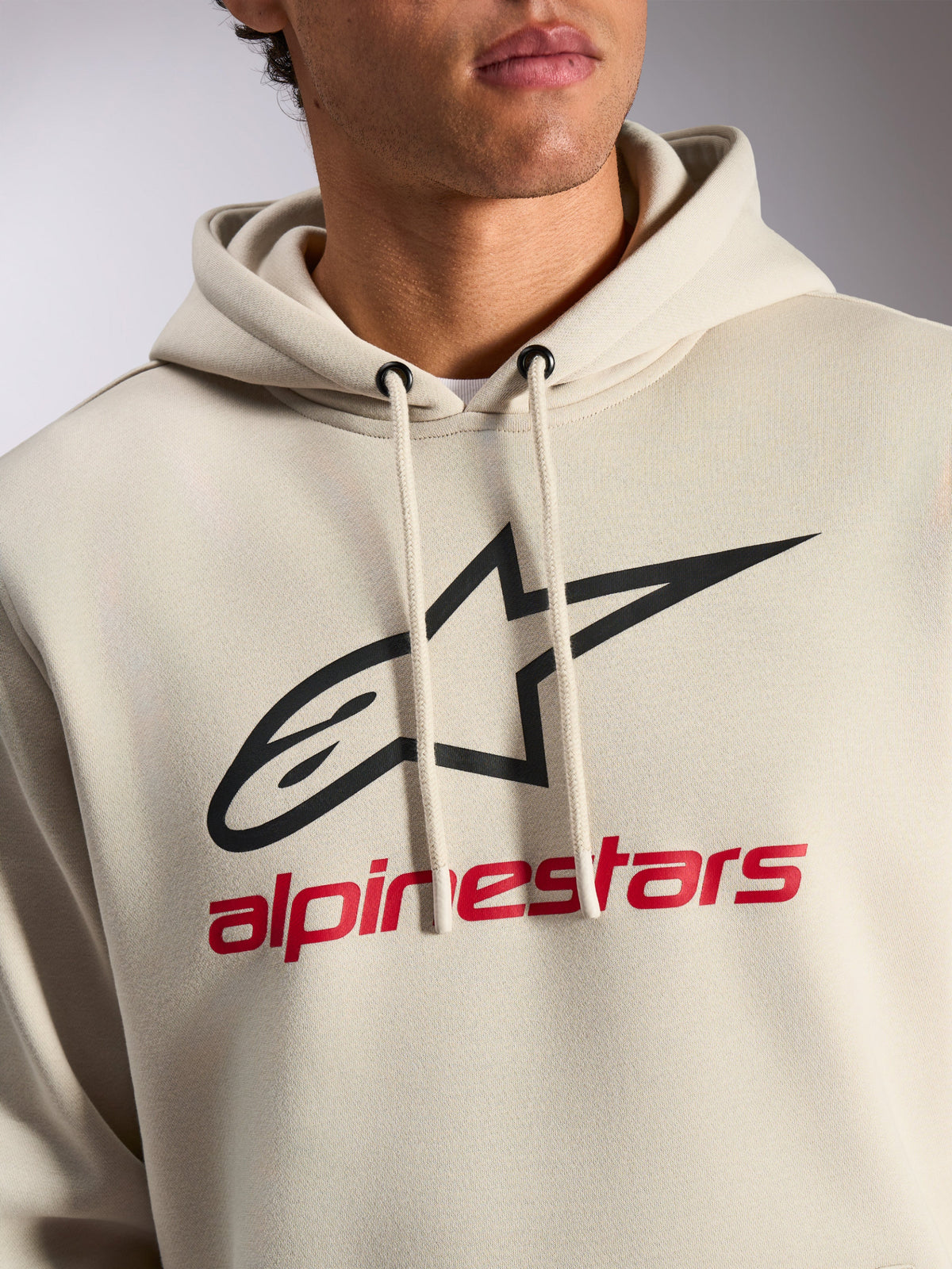 Sudadera Alpinestars Always V3, ropa urbana casual, blanco roto con logotipo de estrella negro y texto Alpinestars en rojo, capucha con cordón, felpa de primera calidad, diseño moderno inspirado en el automovilismo