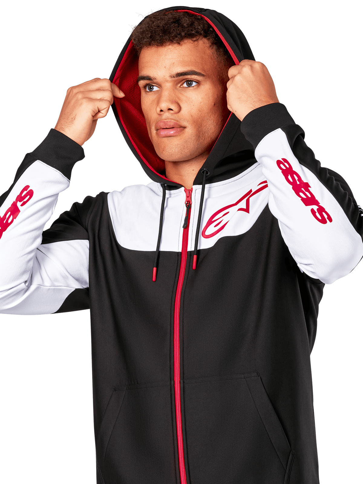 Alpinestars Sessions V3 Hoodie, negro, blanco y rojo, sudadera con cremallera frontal llevada por un hombre con la capucha puesta, con logotipos Alpinestars rojos en el pecho y las mangas, estilo streetwear casual de motorsport