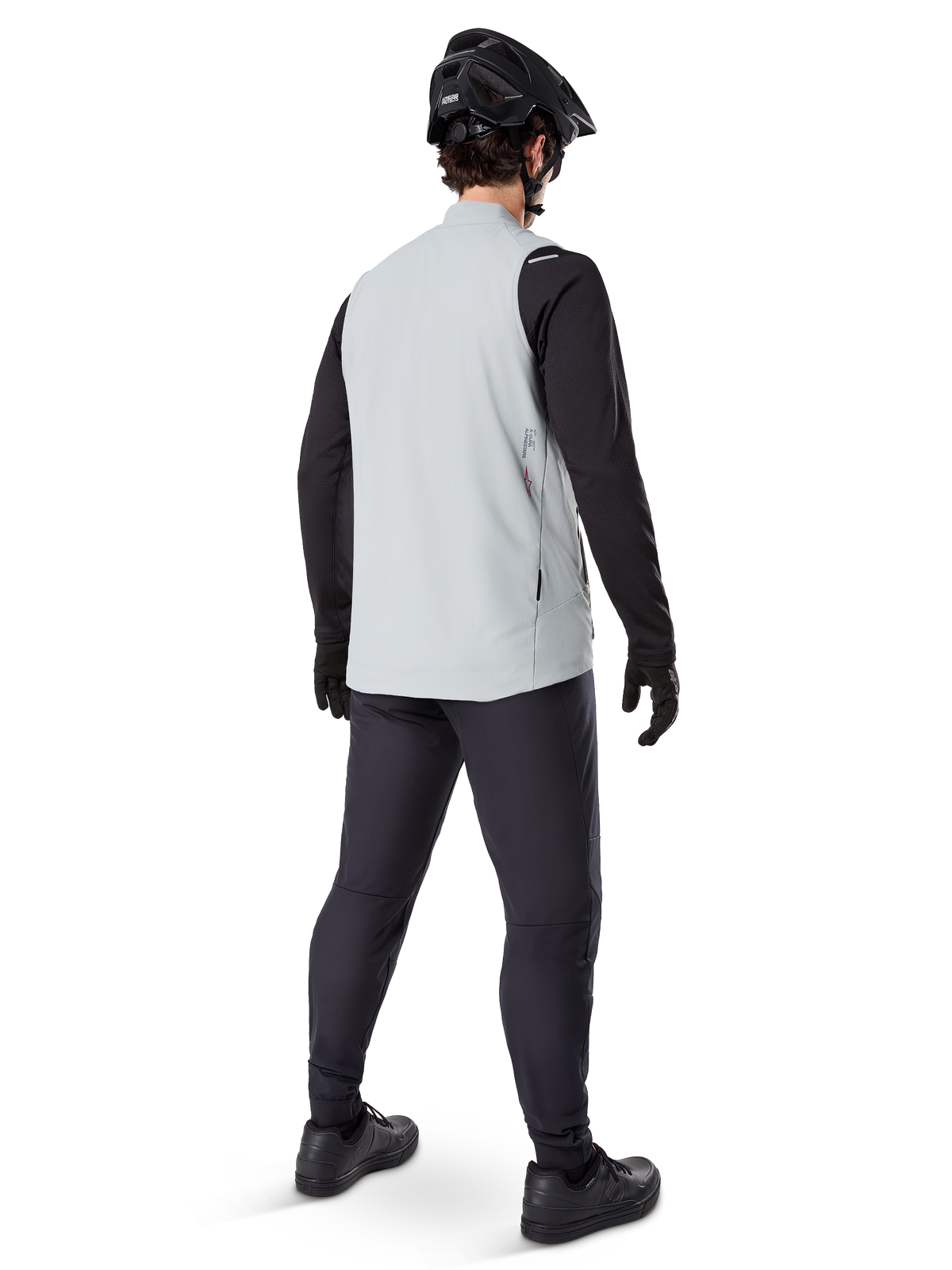Alpinestars A-Dura Thermal Vest, Titanium Gray, rear view of model wearing the insulated cycling vest over a black long-sleeve top and dark pants, complete with a black mountain bike helmet and gloves, designed for cold-weather off-road riding