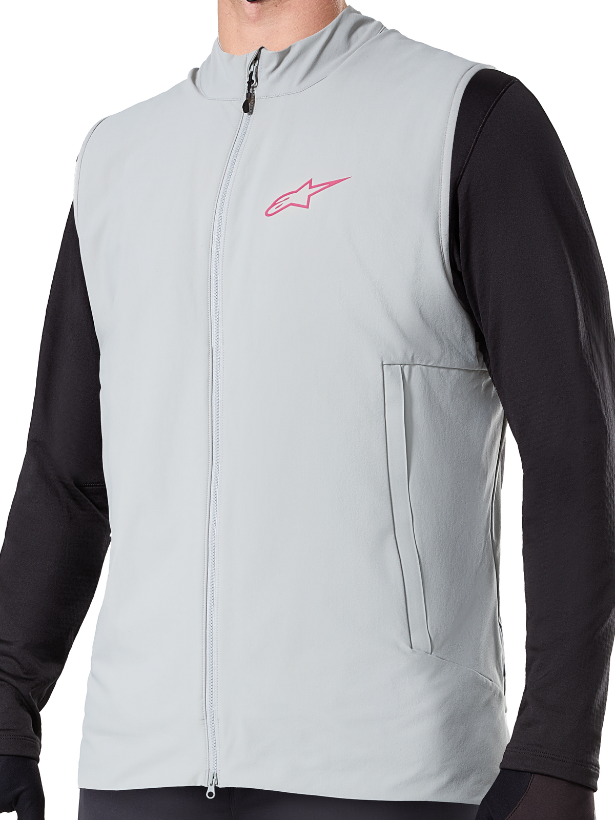 Alpinestars A-Dura Thermal Vest, Titanium Gray insulated cycling gilet, featuring a pink star logo on the chest, worn over a black long-sleeve top, includes a vertical zippered pocket and full front zip, designed for cold-weather mountain bike trail riding.