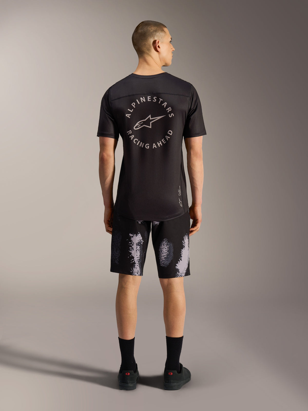 Pantalones cortos A-Dura Ride en Black Camo, duradero diseño de MTB elástico para hombre visto desde atrás en estudio.