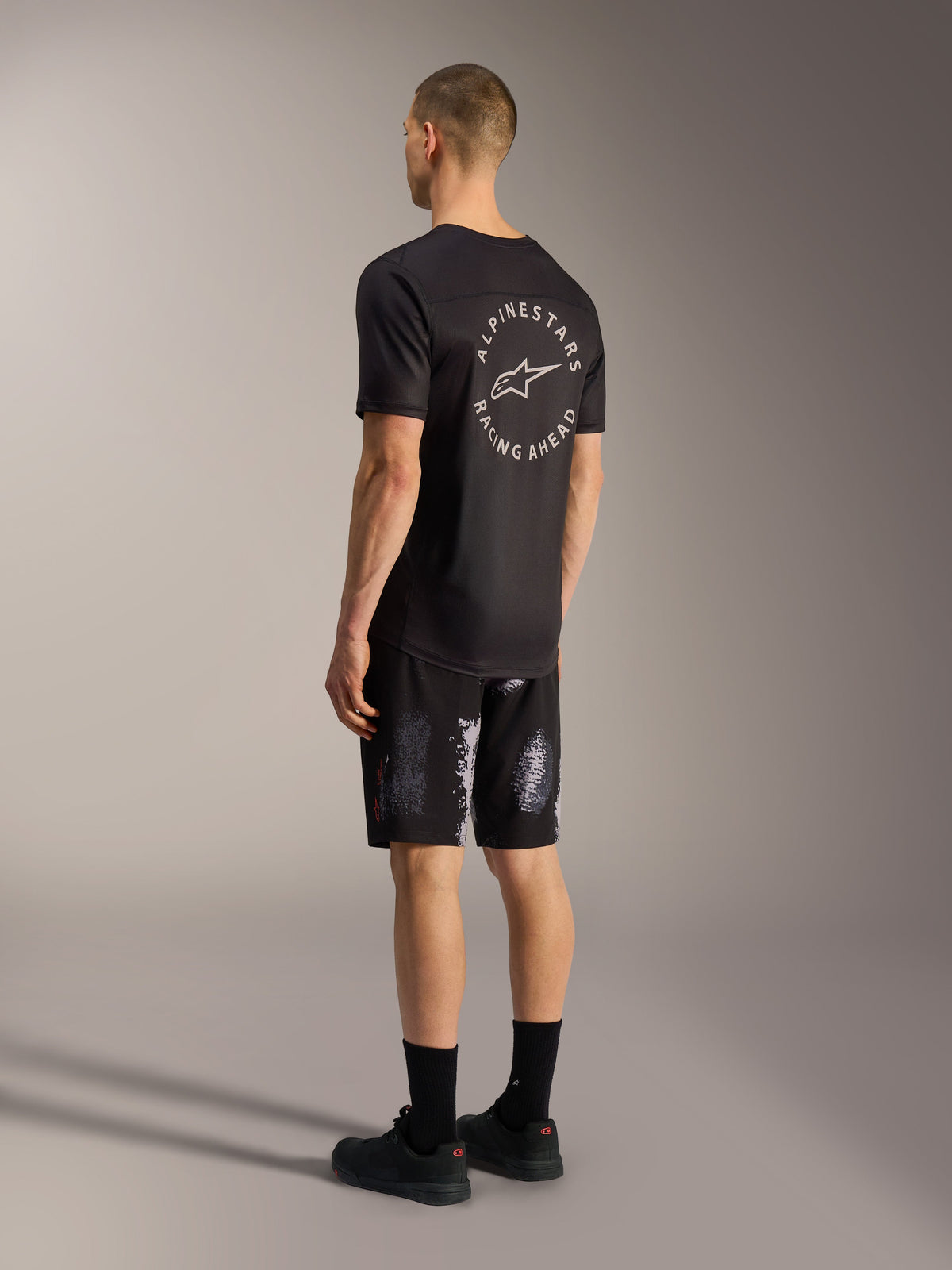 Pantalones cortos A-Dura Ride en camuflaje negro, tejido de MTB elástico en 4 direcciones, vista posterior en un modelo.
