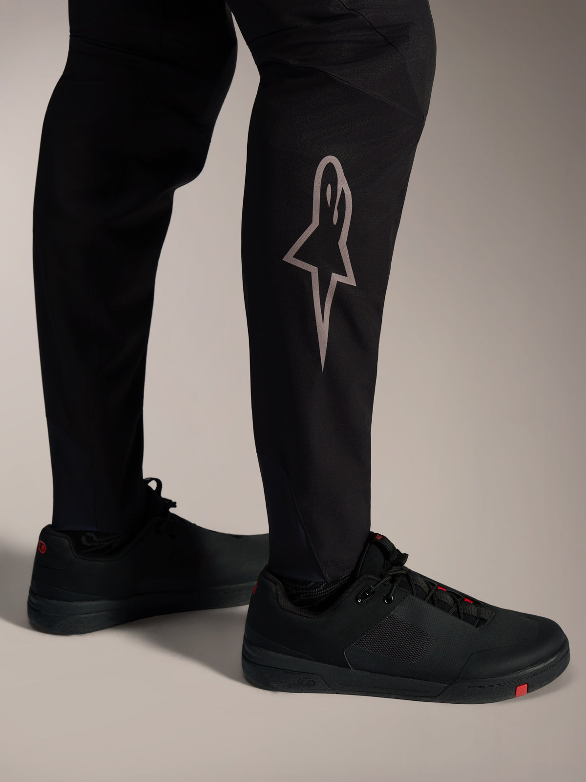 Pantalones MTB A-Supra Elite negros, logotipo Astars plateado en la pierna, diseño de alto rendimiento para ciclismo.