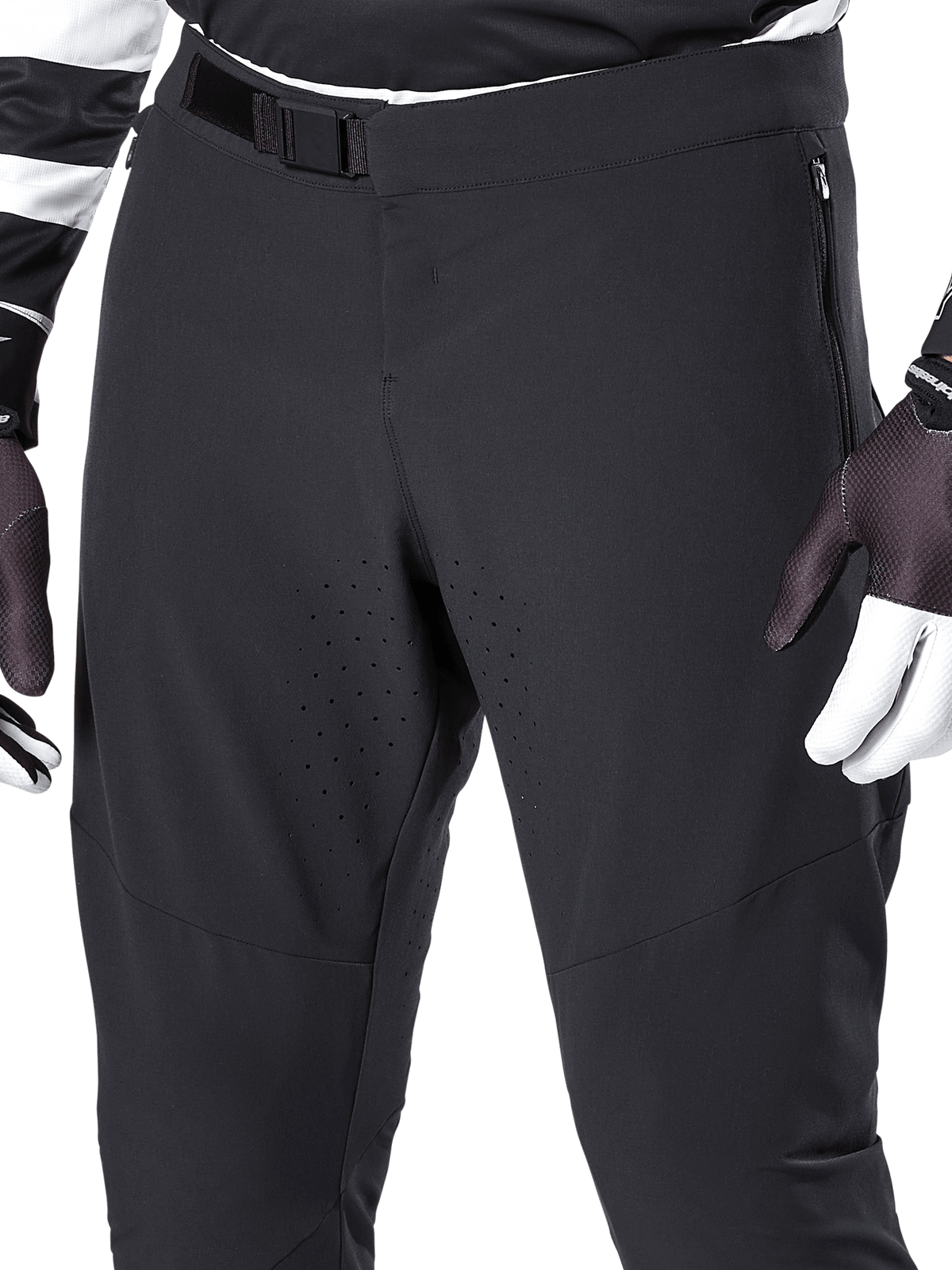 Alpinestars A-Aria Elite Pants, pantalones negros de ciclismo de montaña, primer plano de la cintura frontal y los muslos con cierre de hebilla magnética y orificios de ventilación cortados con láser, combinados con guantes de ciclismo