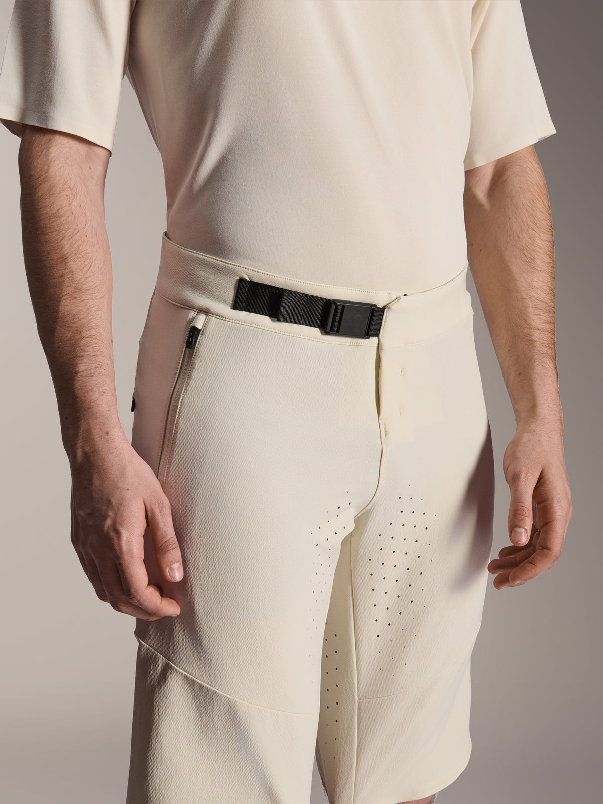 Alpinestars A-Aria Elite Shorts, Mountain Bike Shorts, Ecru, close-up view showing the black magnetic buckle closure, side zippered pocket, and laser-cut ventilation, technical performance cycling apparel