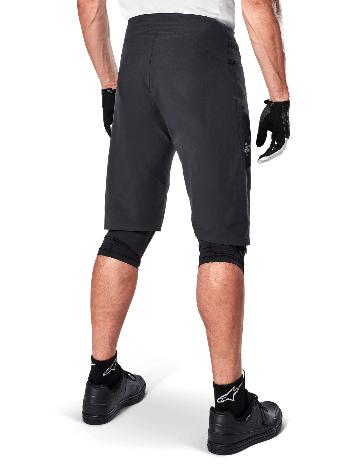 Alpinestars A-Aria Shorts, Mountain Bike Shorts, Black, rear view showing performance fit and clean design, worn with black gloves and socks featuring the white Astars logo, technical cycling apparel for off-road riding