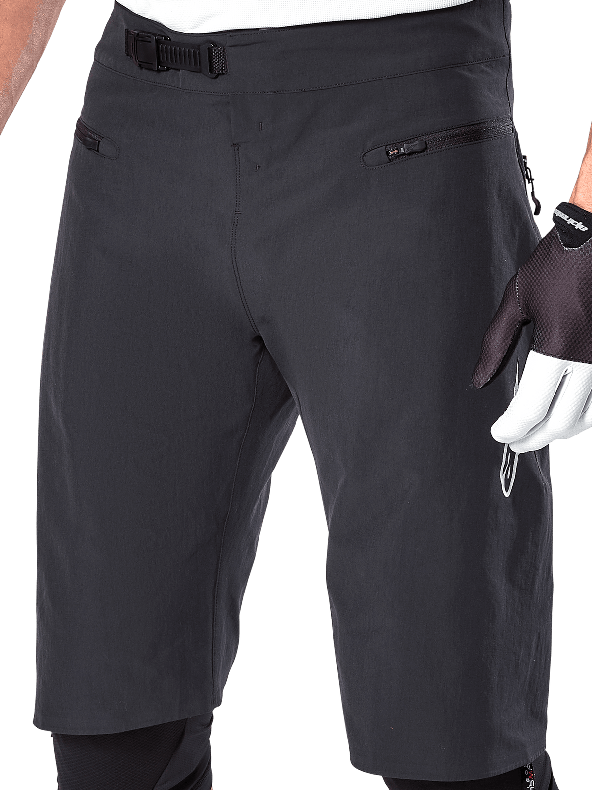 Alpinestars A-Aria Shorts, Mountain Bike Shorts, Black, close-up view of the front waist and thighs showing the ratchet closure system and zippered pockets, worn with black and white cycling gloves, performance trail gear.
