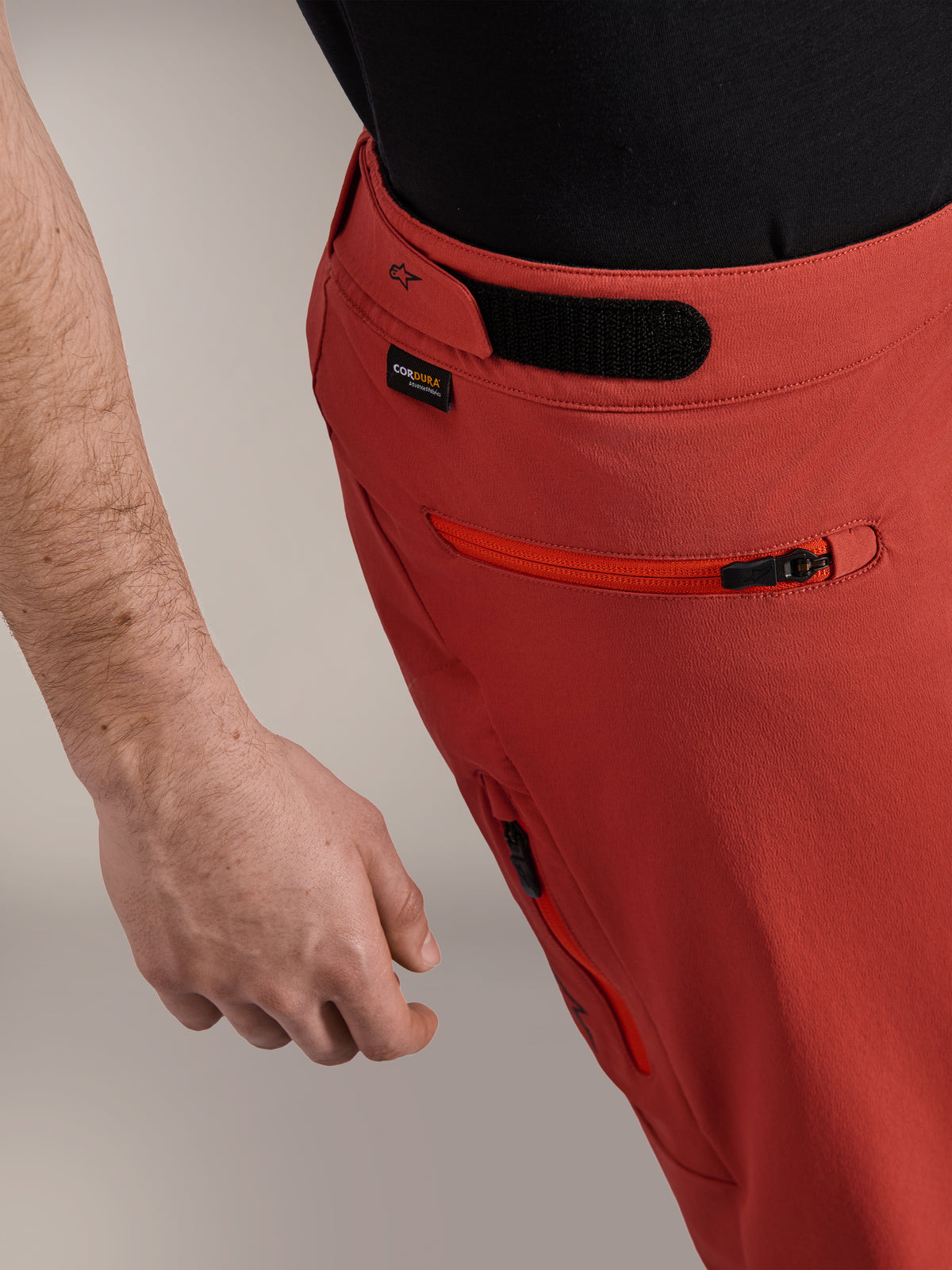 Alpinestars A-Dura Elite Shorts, Naranja Oscuro, primer plano de perfil lateral con ajustador de cintura de gancho y bucle, logotipo de Cordura® y bolsillo lateral con cremallera, shorts premium para mountain bike