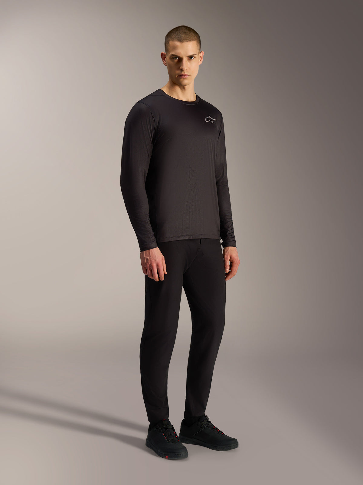 Camiseta Alpinestars A-Dura Air negra, manga larga transpirable de tejido jacquard para MTB con pequeño logo frontal.