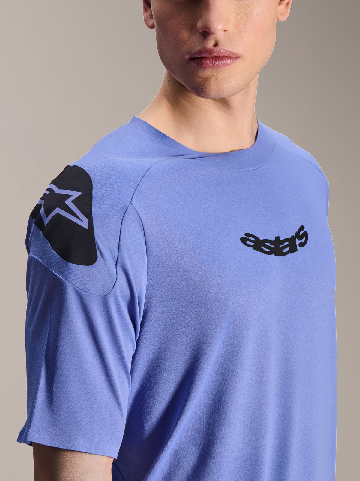 Alpinestars A-Aria Polartec Elite Jersey, jersey de manga corta para bicicleta de montaña, azul Baja Blue, primer plano del pecho y el hombro con el logotipo astars negro y gráfico decorativo, tejido técnico que absorbe la humedad para ciclismo de montaña