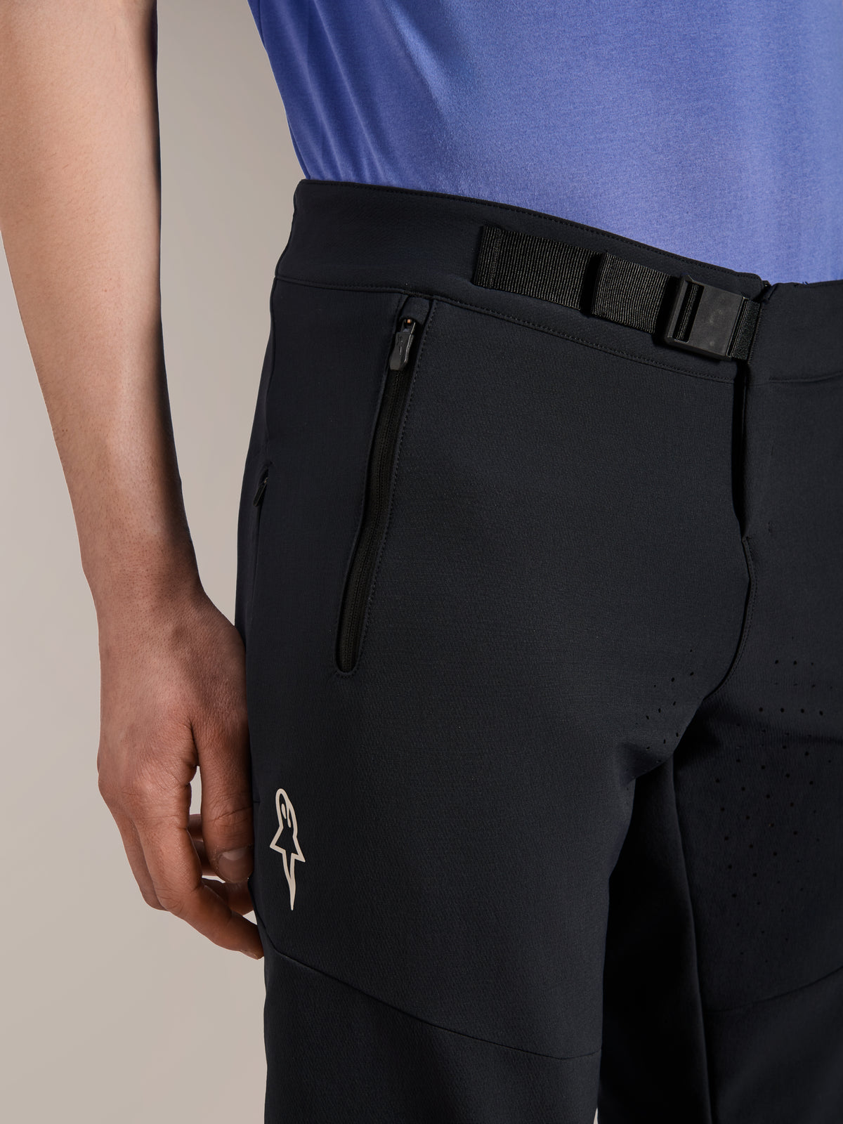 Alpinestars A-Aria Elite Shorts, shorts de ciclismo de montaña, Black Titanium, con un cierre de hebilla magnética, bolsillo con cremallera y logotipo blanco de Alpinestars, combinados con un jersey de ciclismo azul, equipamiento de alto rendimiento para MTB