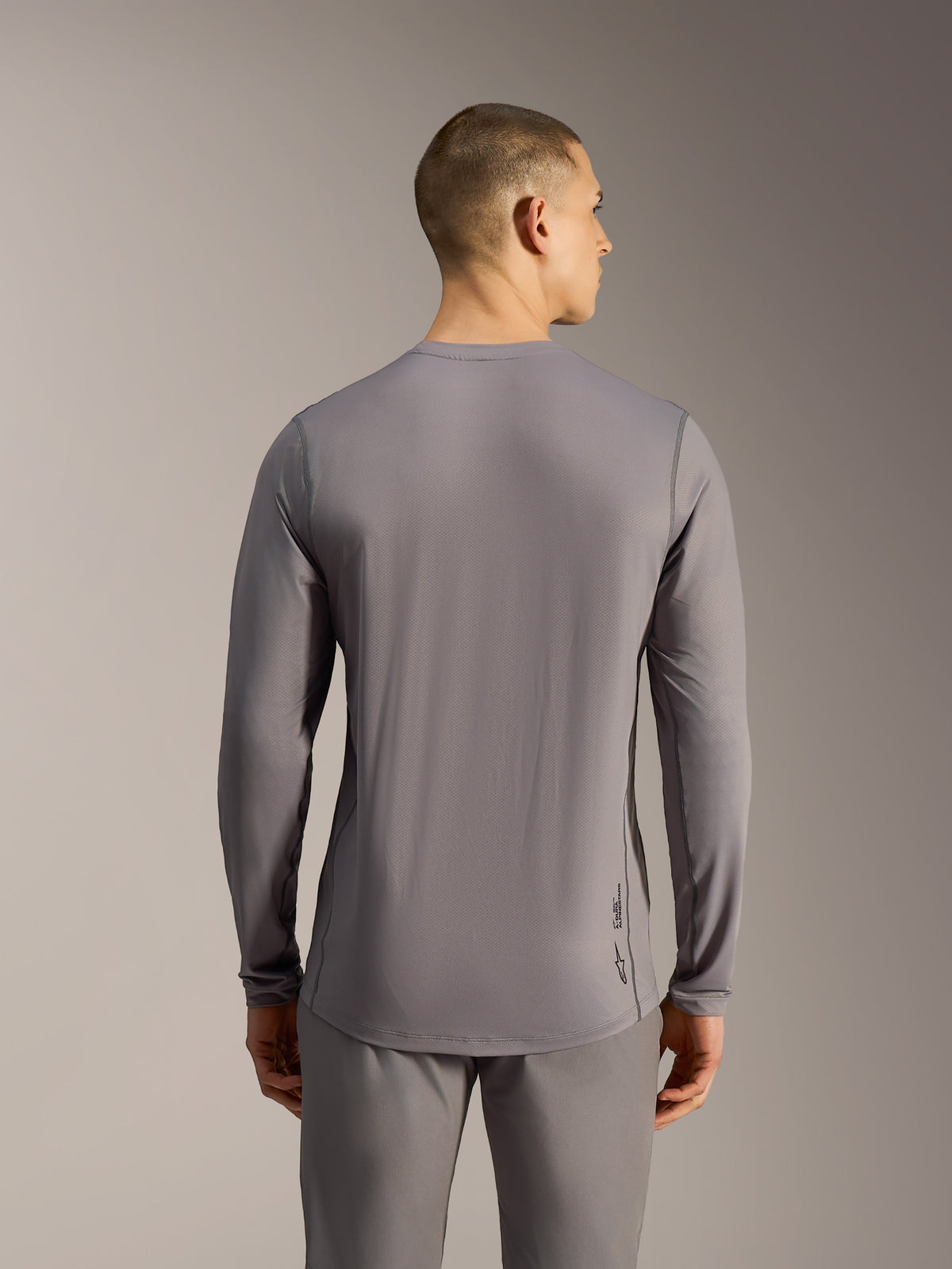 Jersey A-Dura Ride gris de manga larga, prenda técnica de MTB en tejido jacquard con corte trasero más largo.