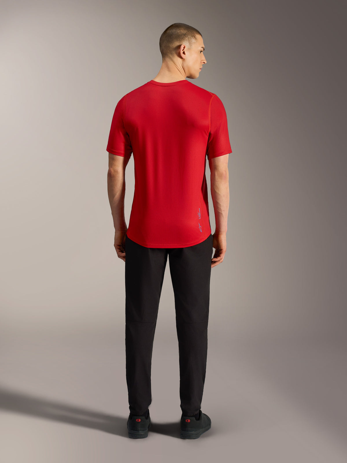 Camiseta A-Dura Ride roja de manga corta, vista trasera con cola caída y tejido ligero técnico para MTB.