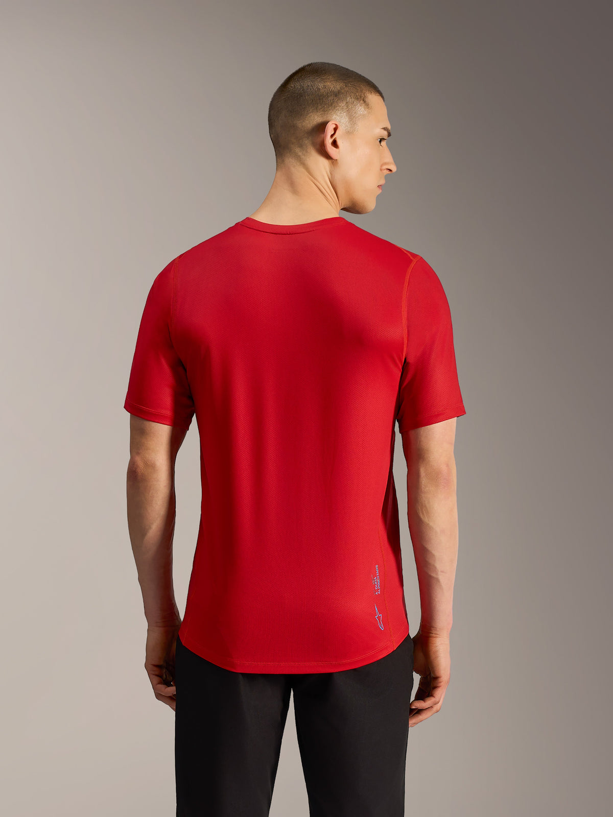 Camiseta MTB A-Dura Ride roja, vista trasera en tejido jacquard con cola caída y sutil logotipo de Alpinestars.