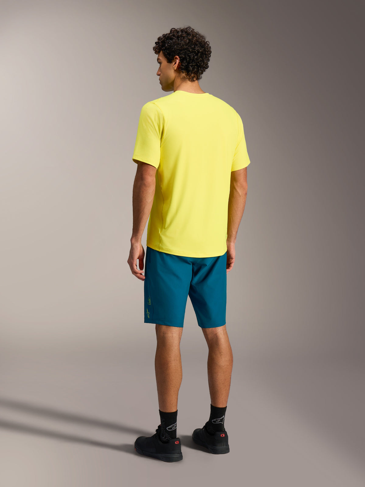 Jersey A-Dura Ride amarillo flúor, vista trasera con diseño de cola larga para rendimiento en ciclismo de montaña.