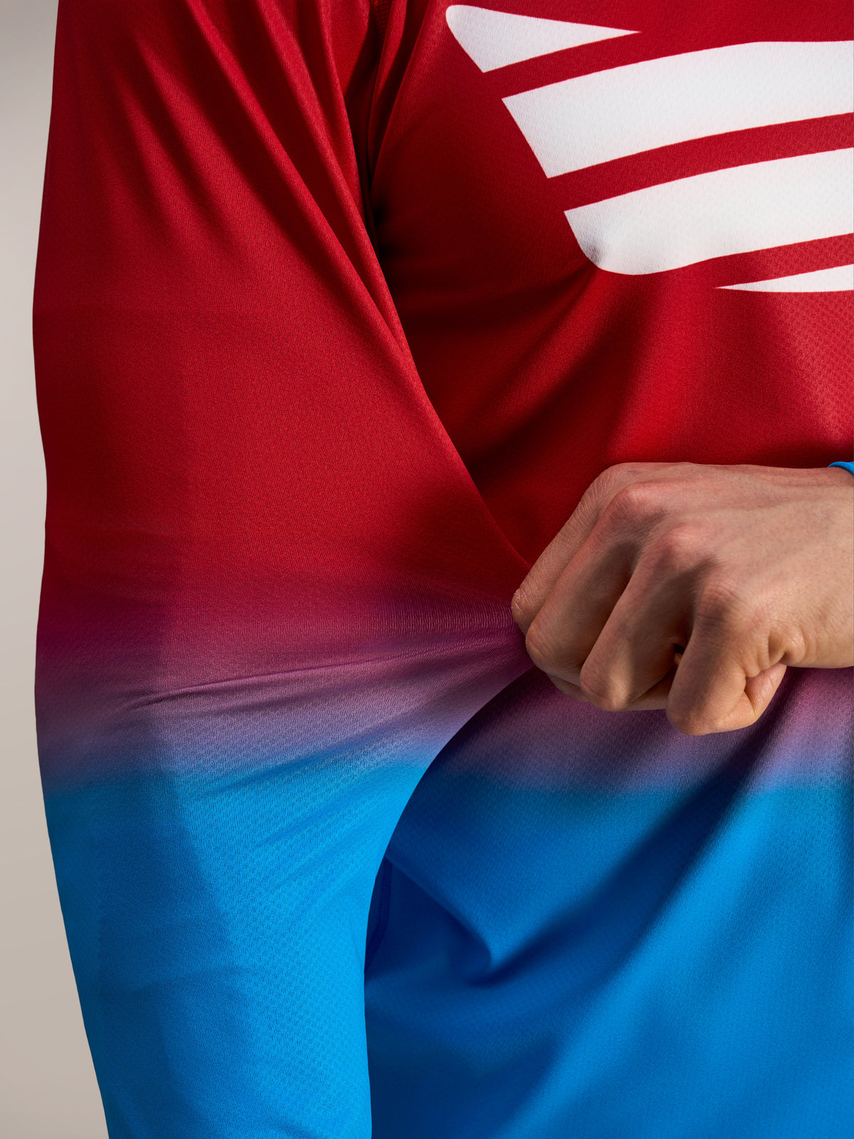 Tejido flexible de poli-spandex rojo y azul en la camiseta Alpinestars A-Dura ASTARS 2.0 de manga larga.